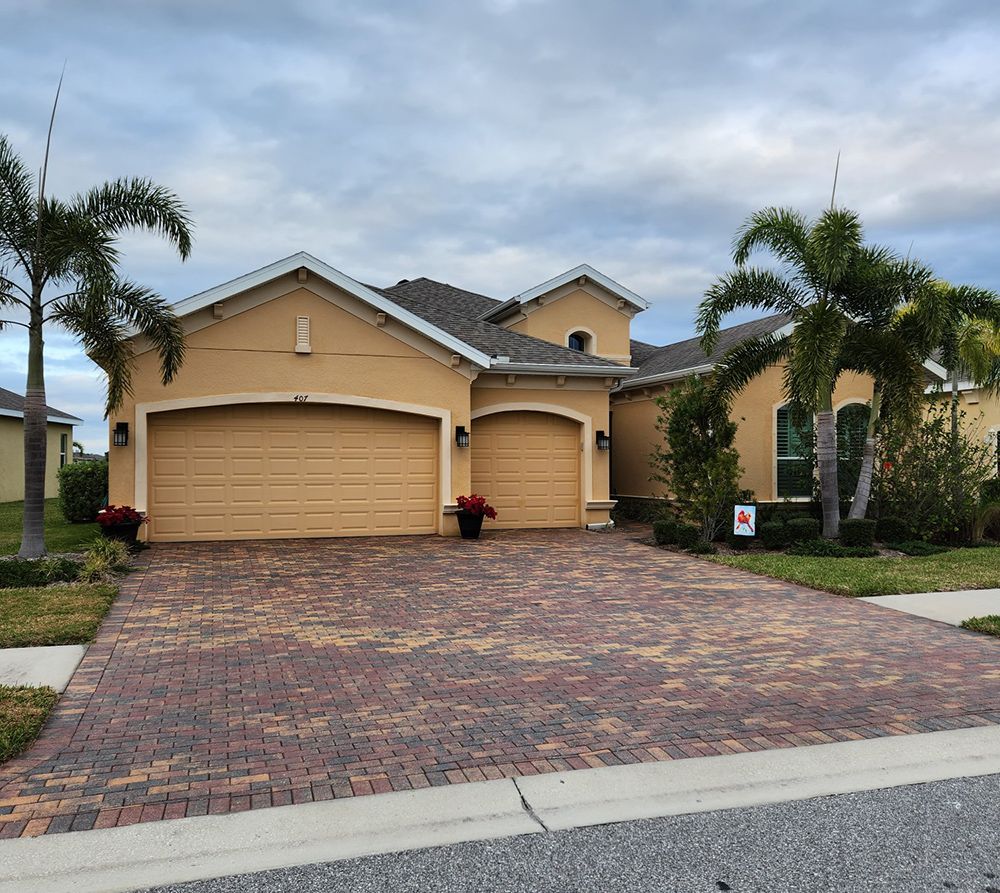 A house with two garage doors and a brick driveway