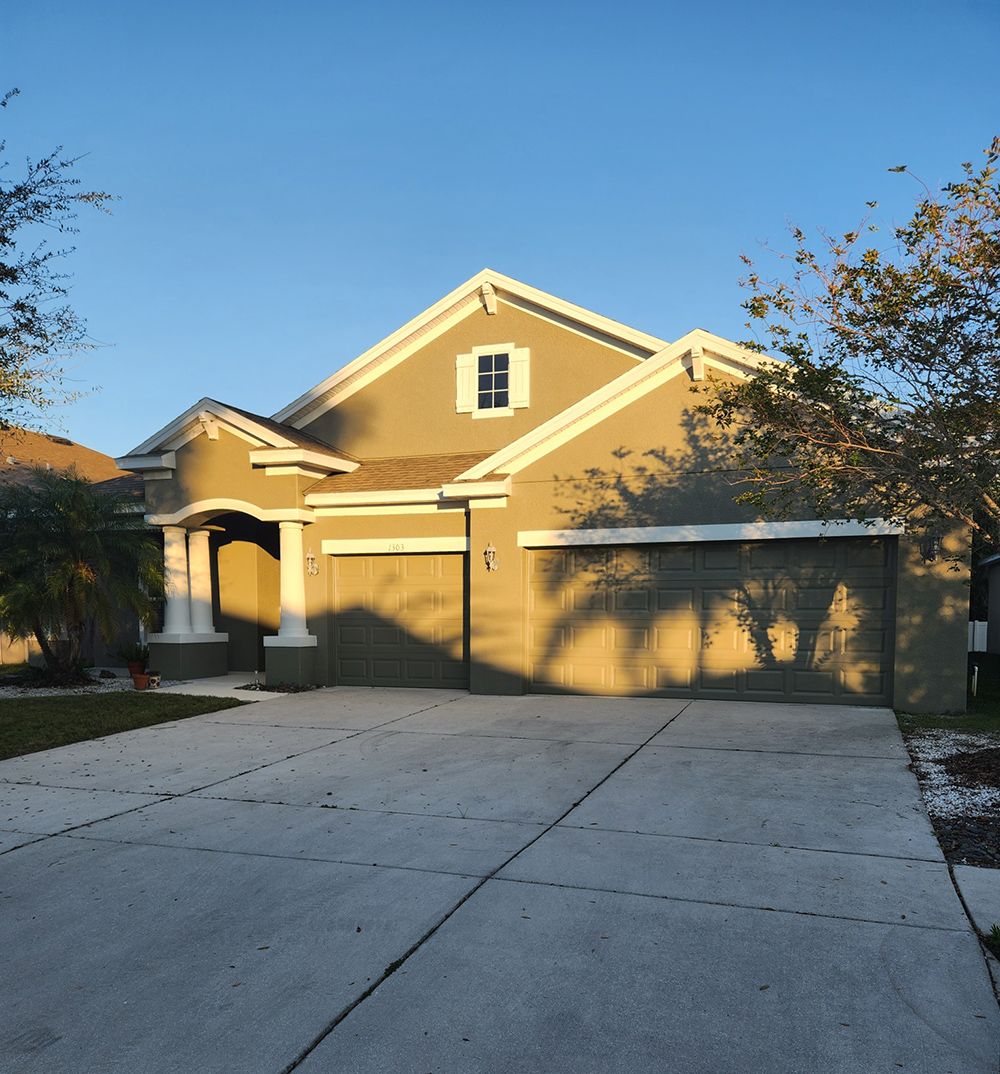 A large house with a concrete driveway in front of it