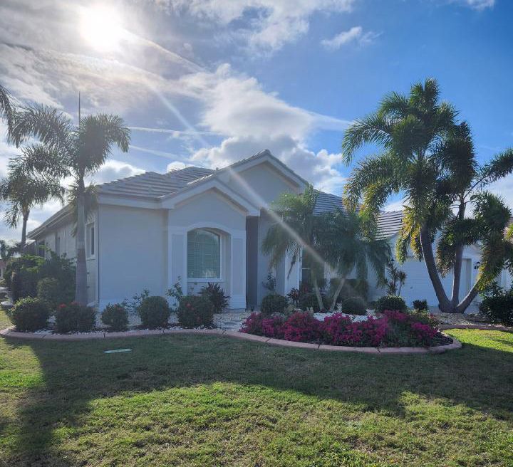 A white house with palm trees in front of it