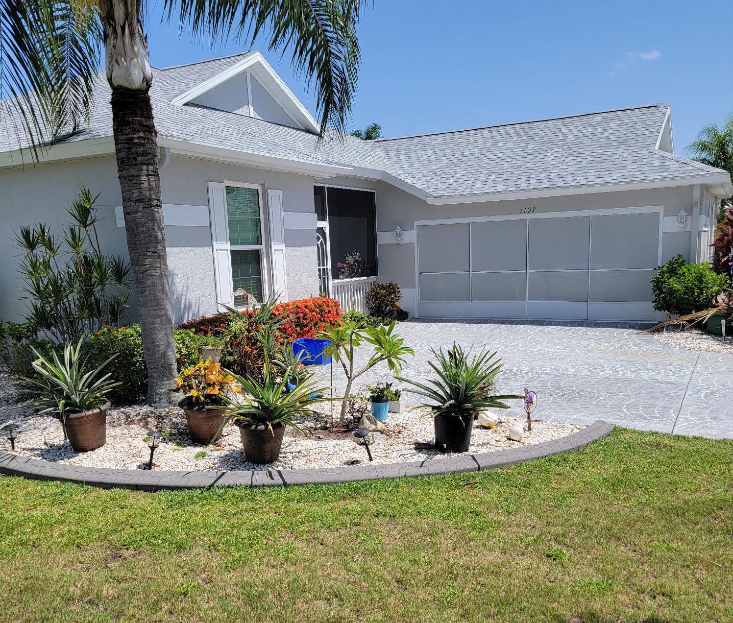 A white house with a palm tree in front of it
