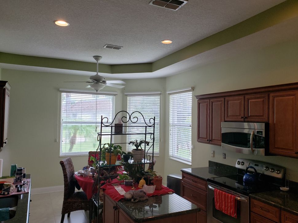 A kitchen with a table and chairs and a ceiling fan